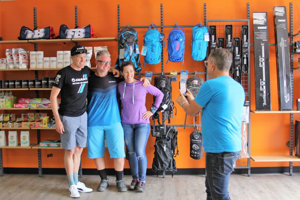 GIANT TEAM OFF-ROAD MEMBER CARL DECKER AND LIV AMBASSADOR LEIGH DONOVAN POSE FOR A PIC WITH A CUSTOMER.